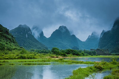 Scenic view of lake and mountains against sky