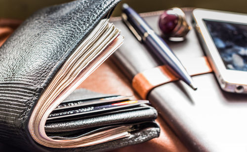 Close-up of wallet and book on table