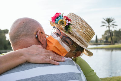 Portrait of man holding woman against sky