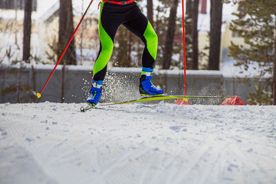 Low section of man skateboarding on snow