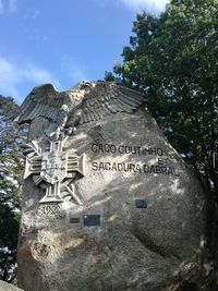 Low angle view of text on stone wall against sky