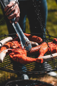 Close-up of person preparing food on barbecue grill