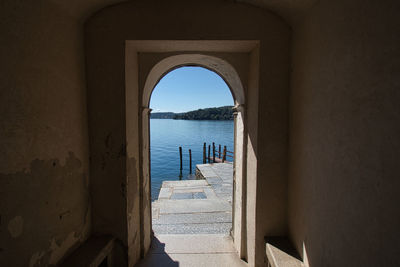 Scenic view of lake against sky seen through wall