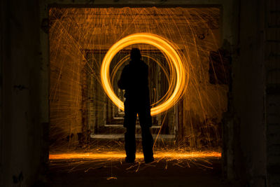 Rear view of person standing by light trails