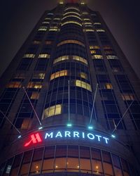 Low angle view of illuminated skyscraper against sky at night