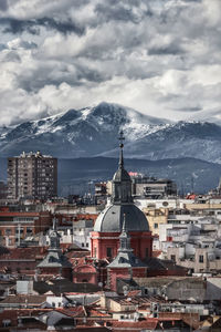 Aerial view of townscape against cloudy sky