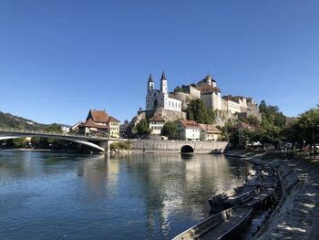 Bridge over river against buildings in city