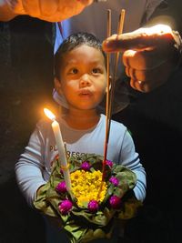 Portrait of cute boy holding flowering plant