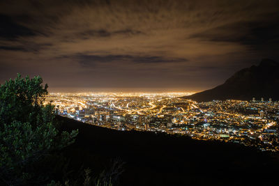 Illuminated cityscape against sky at night