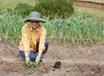 Full length of senior woman wearing hat on field