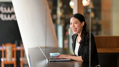Young woman using laptop at table
