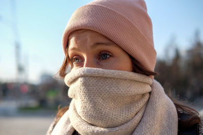 Close-up of woman wearing scarf and knit hat outdoors during winter