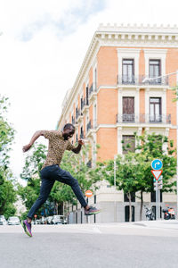 Man jumping on road in city