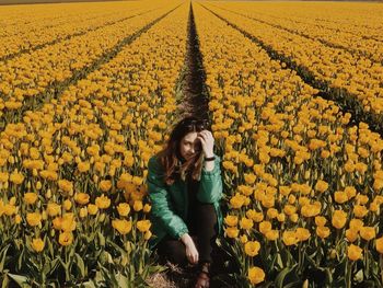 Full length of woman with yellow flowers