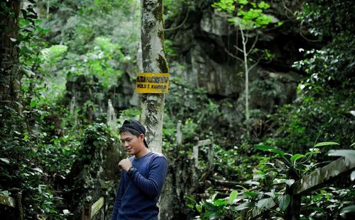 Side view of young man looking at forest