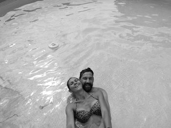 High angle portrait of couple swimming in pool