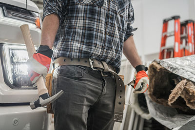 Midsection of man standing in car