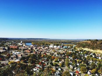 High angle view of cityscape by sea against clear sky