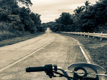 Cropped image of motorcycle on road against sky