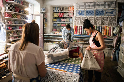 Male and female owners working in fabric shop