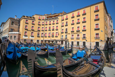 Boats moored in canal against buildings in city