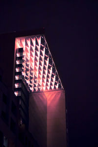Low angle view of illuminated building against sky at night