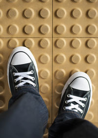 Low section of man standing on tiled floor