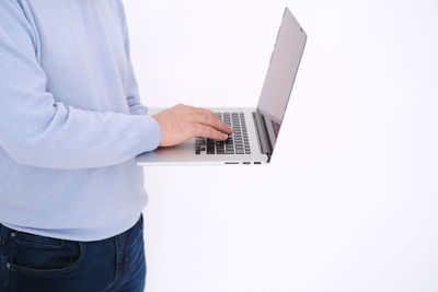 Midsection of man using laptop against white background