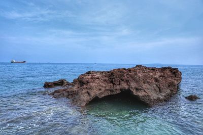 Rock formation in sea against sky