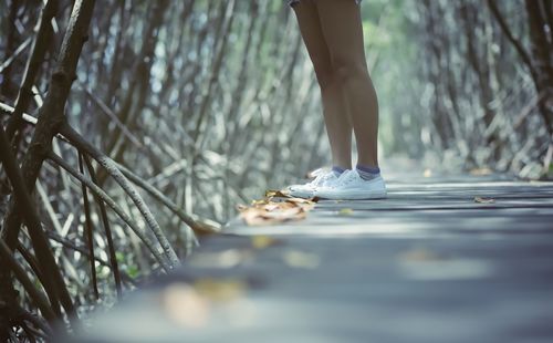 Low section of woman standing on retaining wall