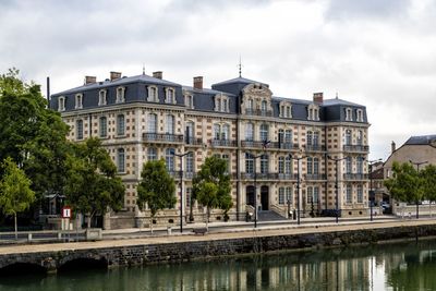View of bridge over river in city against sky