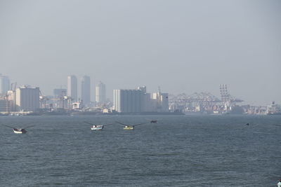 View of city by sea against clear sky