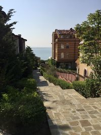 Houses amidst trees and buildings against sky