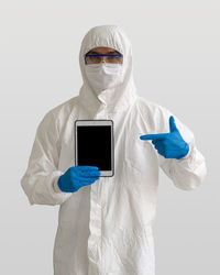 Portrait of man holding mobile phone against white background
