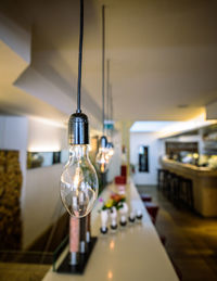 Illuminated light bulbs hanging in restaurant