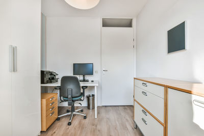 View of chair and computer at bedroom