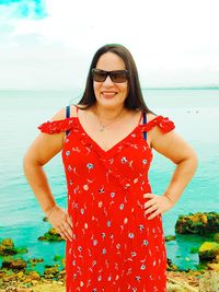 Young woman wearing sunglasses standing on beach