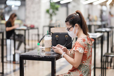 Woman holding smart phone in cafe