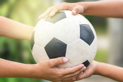 Close-up of hands playing soccer ball