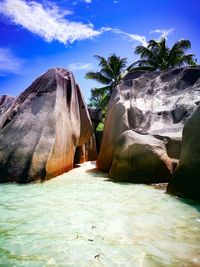 Scenic view of rocks by sea against sky