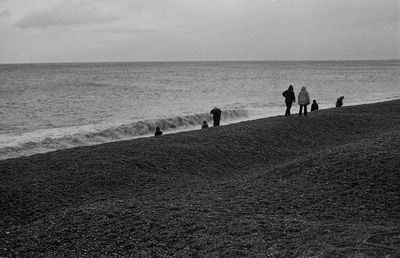 Group of people on beach against the sky