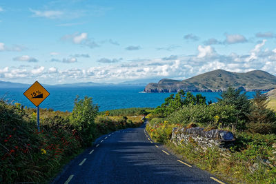 Road by sea against blue sky