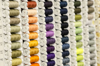 Full frame shot of colorful spools on rack