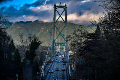 Cars on bridge in city against sky