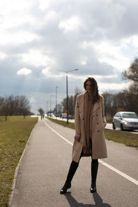 Woman standing on road against sky