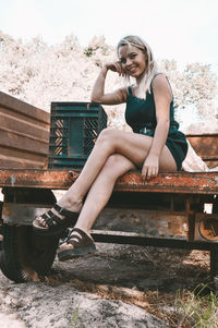 Young woman sitting on bench in park