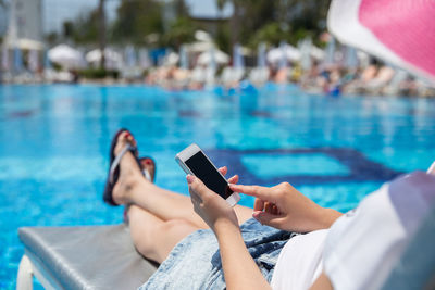 Woman using mobile phone in swimming pool