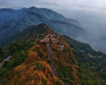 Aerial view of building on hill against mountains