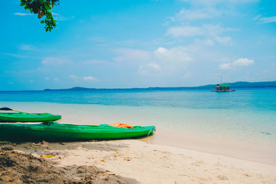 Boat moored on beach against sky