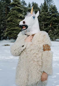 View of a man with horse mask on snow covered land